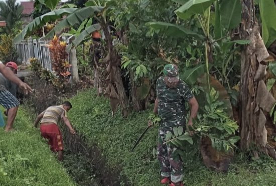 Kompak, Babinsa Bersama Warga Tabobol Bersihkan Saluran Air di Kiri Kanan Bahu Jalan