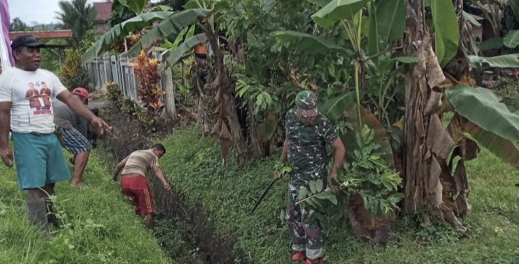 Kompak, Babinsa Bersama Warga Tabobol Bersihkan Saluran Air di Kiri Kanan Bahu Jalan